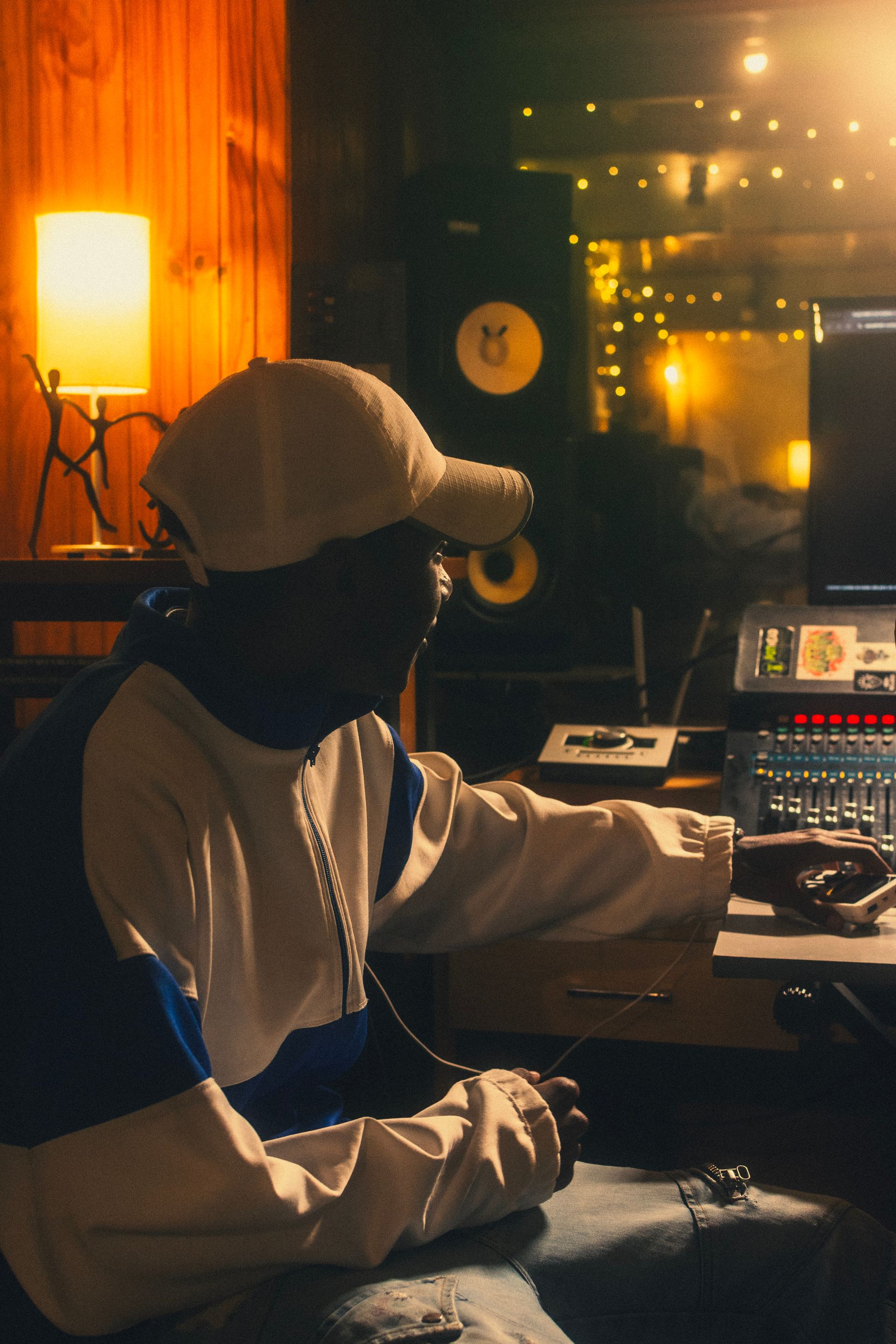 An artist at a small desk under lamplight, working late